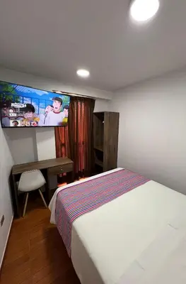 a bedroom with a bed and a tv on the wall at Golden Paris Hotel 