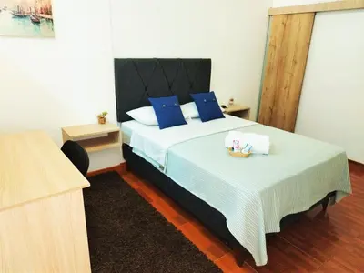 a bedroom with a large bed with blue pillows at Hermosa Habitación c/ Baño privado - Huacachina. in Ica