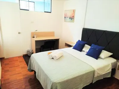 a bedroom with a large bed with blue pillows at Hermosa Habitación c/ Baño privado - Huacachina. in Ica