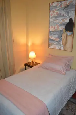 a bedroom with a bed with a lamp and a painting at Lima Guest Room House in Lima
