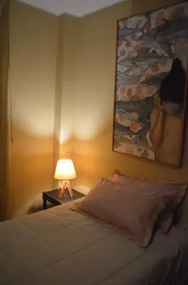 a bedroom with a bed and a painting on the wall at Lima Guest Room House in Lima