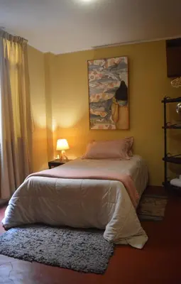 a bedroom with a large bed with a rug at Lima Guest Room House in Lima