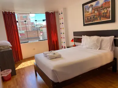 a bedroom with a large bed and a window at Adriano's Deluxe Apartments 3 in Cusco
