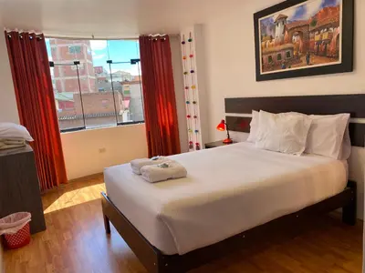 a bedroom with a large bed and a window at Adriano's Deluxe Apartments 3 in Cusco