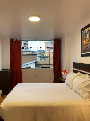 a bedroom with a large bed and a window at Adriano's Deluxe Apartments 3 in Cusco
