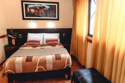 a bedroom with a bed and a window at Qosqo Wasi in Cusco