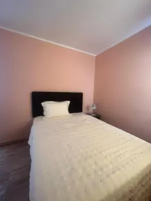 a bedroom with a large white bed in a room at CARDOS HOSTAL in Pisco