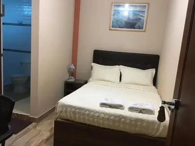 a bedroom with a bed with two towels on it at CARDOS HOSTAL in Pisco