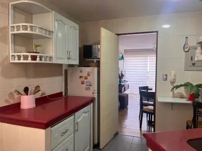 a kitchen with white cabinets and a red counter top at Céntrico y funcional apartamento 2 dormitorios JESÚS MARÍA LIMA in Lima