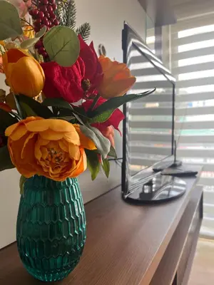 a green vase filled with flowers on a table at Céntrico y funcional apartamento 2 dormitorios JESÚS MARÍA LIMA in Lima