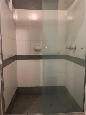 a shower with a glass door in a bathroom at Céntrico y funcional apartamento 2 dormitorios JESÚS MARÍA LIMA in Lima