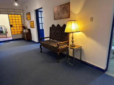 a room with a chair and a lamp on a table at yuraqtampu- Pardo in Cusco