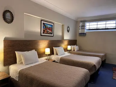a hotel room with two beds and a window at yuraqtampu- Pardo in Cusco