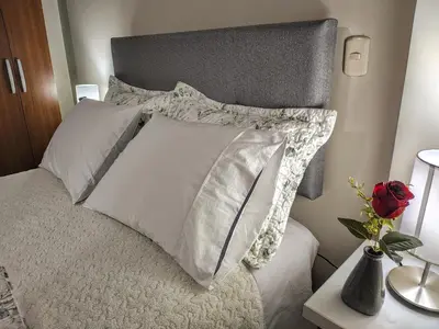 a bed with white pillows on top of it at Zisary's House Apartment in Cusco