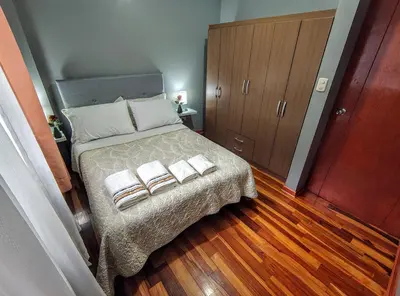 a bedroom with a bed with two towels on it at Zisary's House Apartment in Cusco