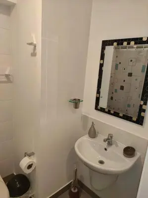 a white bathroom with a sink and a mirror at Met Moderno Departamento in Lima