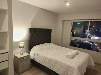 a bedroom with a bed and a window with a city at Met Moderno Departamento in Lima