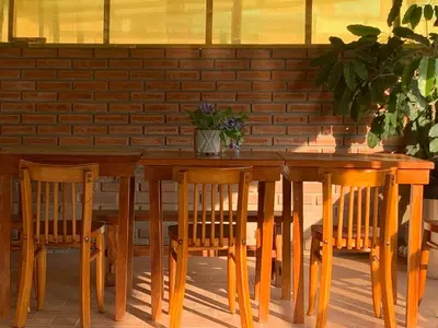 a wooden table with two chairs and a table with a plant at Lindo depa san miguel, 3camas, wifi, terraza. in Lima