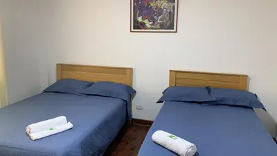 two beds sitting next to each other in a room at Lindo depa san miguel, 3camas, wifi, terraza. in Lima