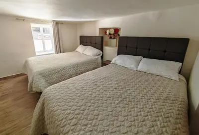 a bedroom with two beds and a window at Centro Cusco Inti Saphy in Cusco