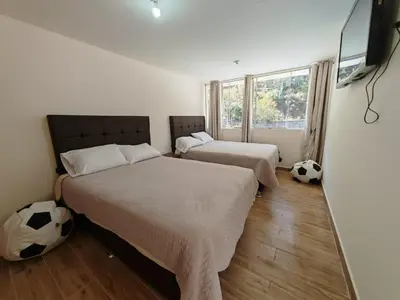 two beds in a bedroom with two soccer balls on the floor at Centro Cusco Inti Saphy in Cusco