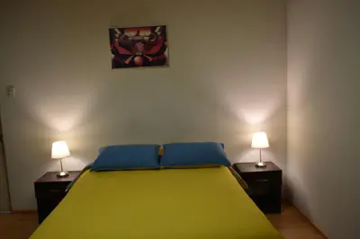 a bedroom with a green bed with two night stands at saga andina in Cusco