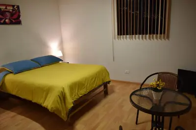 a bedroom with a bed and a table and a window at saga andina in Cusco