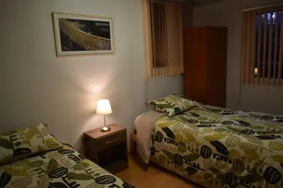 a bedroom with two beds and a lamp on a table at saga andina in Cusco