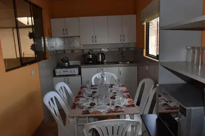 a kitchen with a table and chairs with glasses on it at saga andina in Cusco