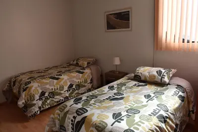a bedroom with two beds and a window at saga andina in Cusco