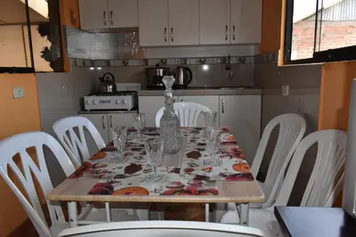 a dining room table with white chairs around it at saga andina in Cusco