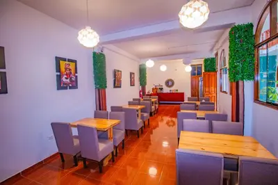 a restaurant with tables and chairs and plants at Munay Ñusta Cusco in Cusco