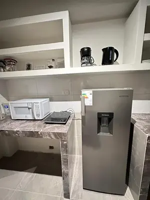 a kitchen with a counter with a refrigerator at Dpto a 3 min Plaza Huánuco y 1 cuadra Open Plaza in Huánuco