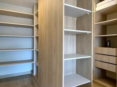 a walk in closet with wooden shelves at Pod by Wynwood House in Lima