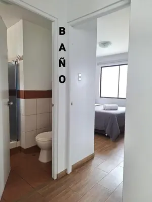 a bathroom with a toilet and a bed in a room at Miraflores - Dormitorio en Departamento compartido Baño Exclusivo Externo in Lima