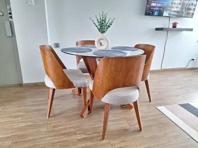 a dining room table with chairs and a vase on it at Miraflores - Dormitorio en Departamento compartido Baño Exclusivo Externo in Lima
