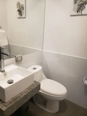 a white bathroom with a toilet and a sink at Central, petfriendly family apartment in Lima
