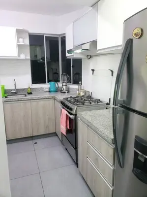 a kitchen with a stove and a refrigerator at Central, petfriendly family apartment in Lima