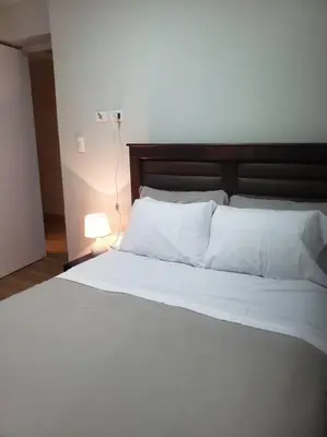 a bedroom with a white bed with a lamp at Central, petfriendly family apartment in Lima