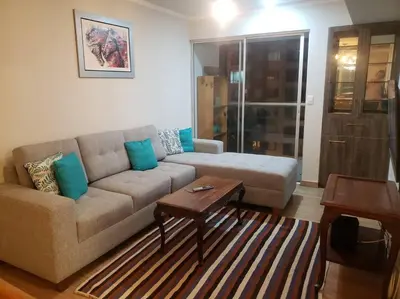 a living room with a couch and a table at Central, petfriendly family apartment in Lima
