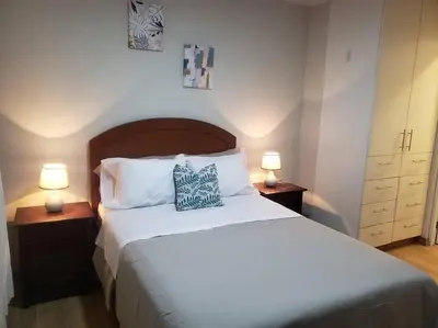 a bedroom with a large bed with two lamps on tables at Central, petfriendly family apartment in Lima