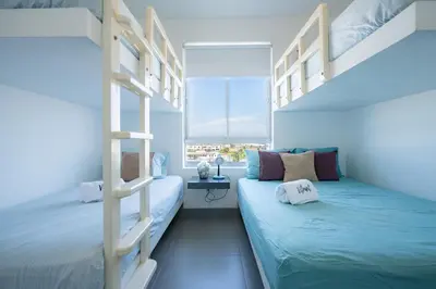 a bedroom with two bunk beds and a window at Sotavento Oceanfront Condos by Vibrant in Paracas