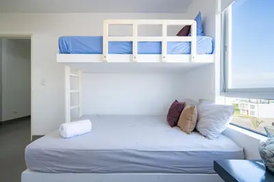 a bedroom with two bunk beds and a window at Sotavento Oceanfront Condos by Vibrant in Paracas