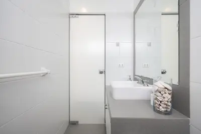 a white bathroom with a sink and a mirror at Sotavento Oceanfront Condos by Vibrant in Paracas