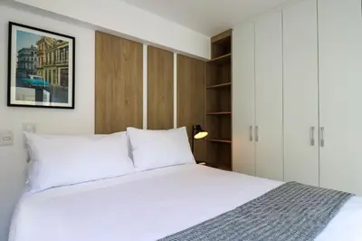 a bedroom with a large white bed and cabinets at Gray by Wynwood House in Lima