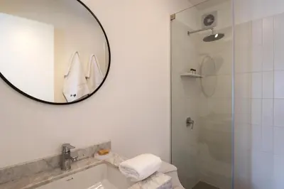 a bathroom with a mirror and a sink and a shower at Gray by Wynwood House in Lima
