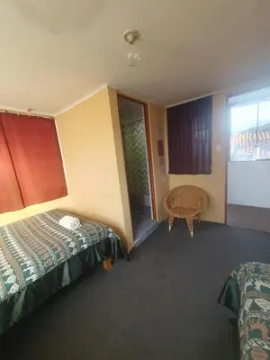 a hotel room with two beds and a window at Royal Frankenstein Hostel in Cusco