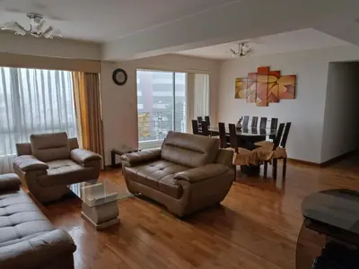 a living room with a couch and chairs and a table at Comfortapartment in Lima
