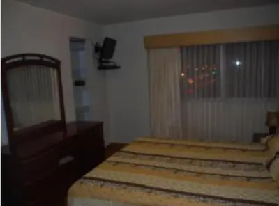 a bedroom with a bed and a dresser and a window at Comfortapartment in Lima