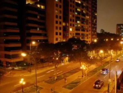 a city street at night with cars and street lights at Comfortapartment in Lima